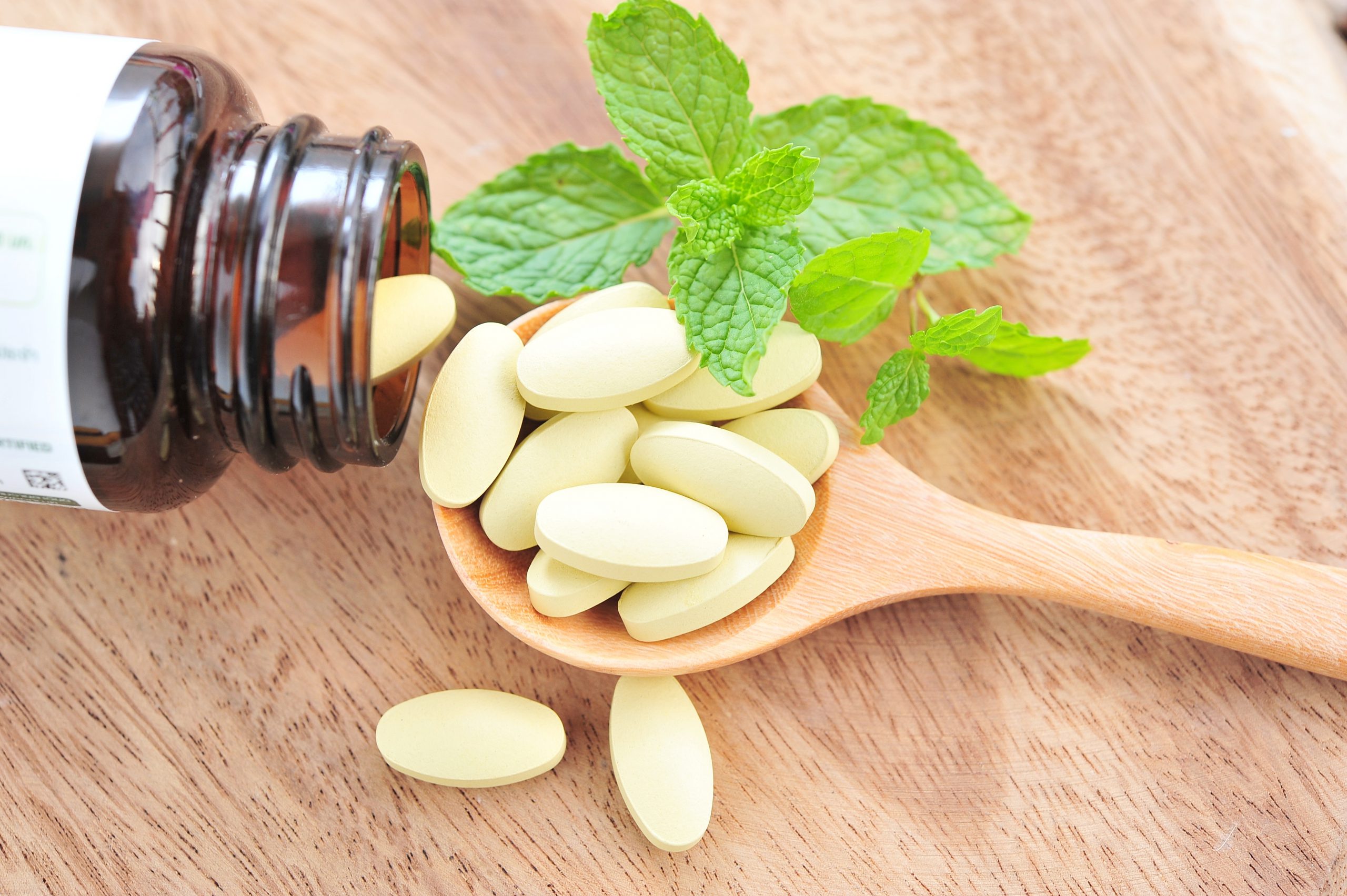 Image of pills on a wooden spoon